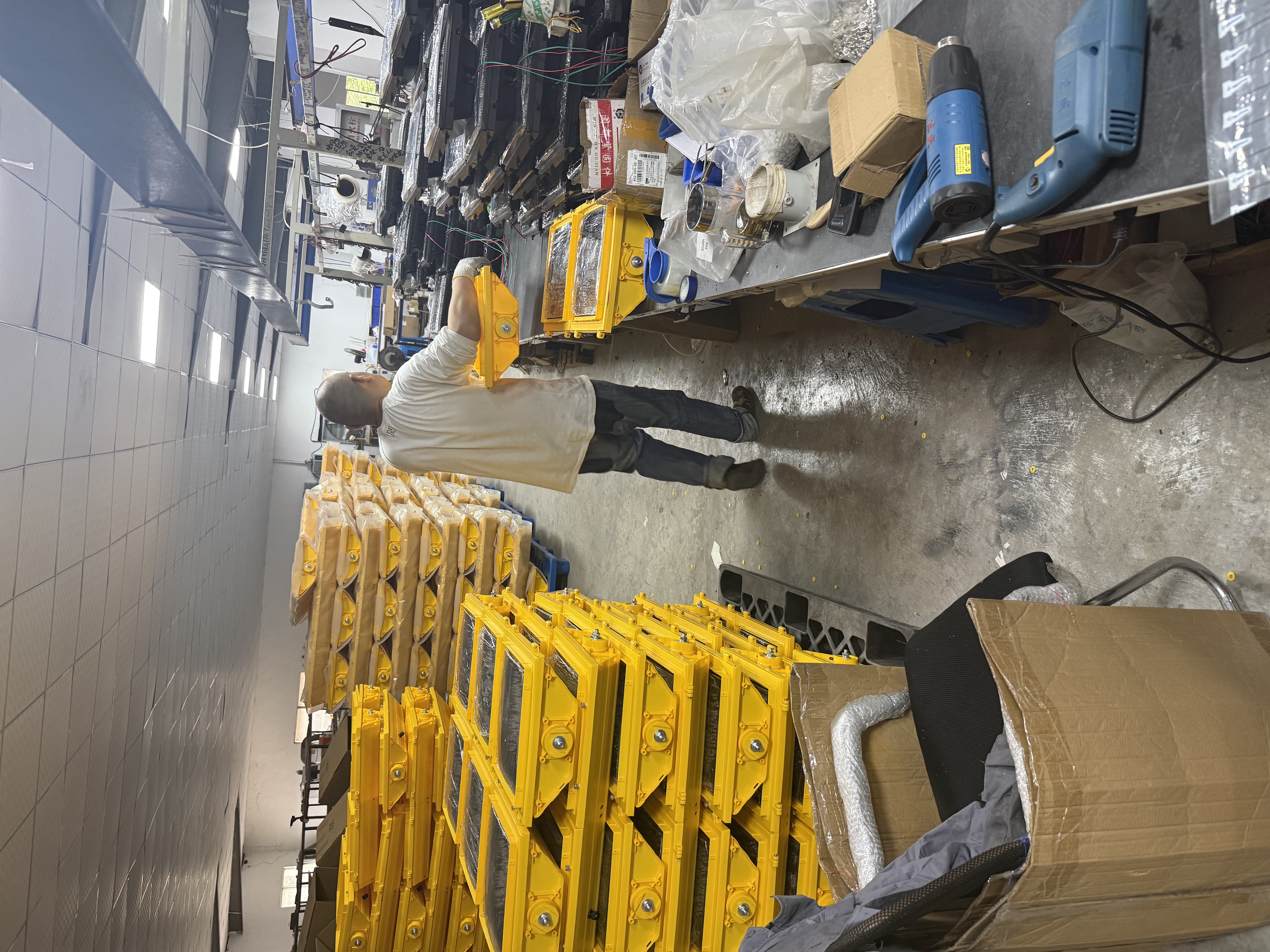 Traffic signal assembly workshop with yellow housings and workbenches