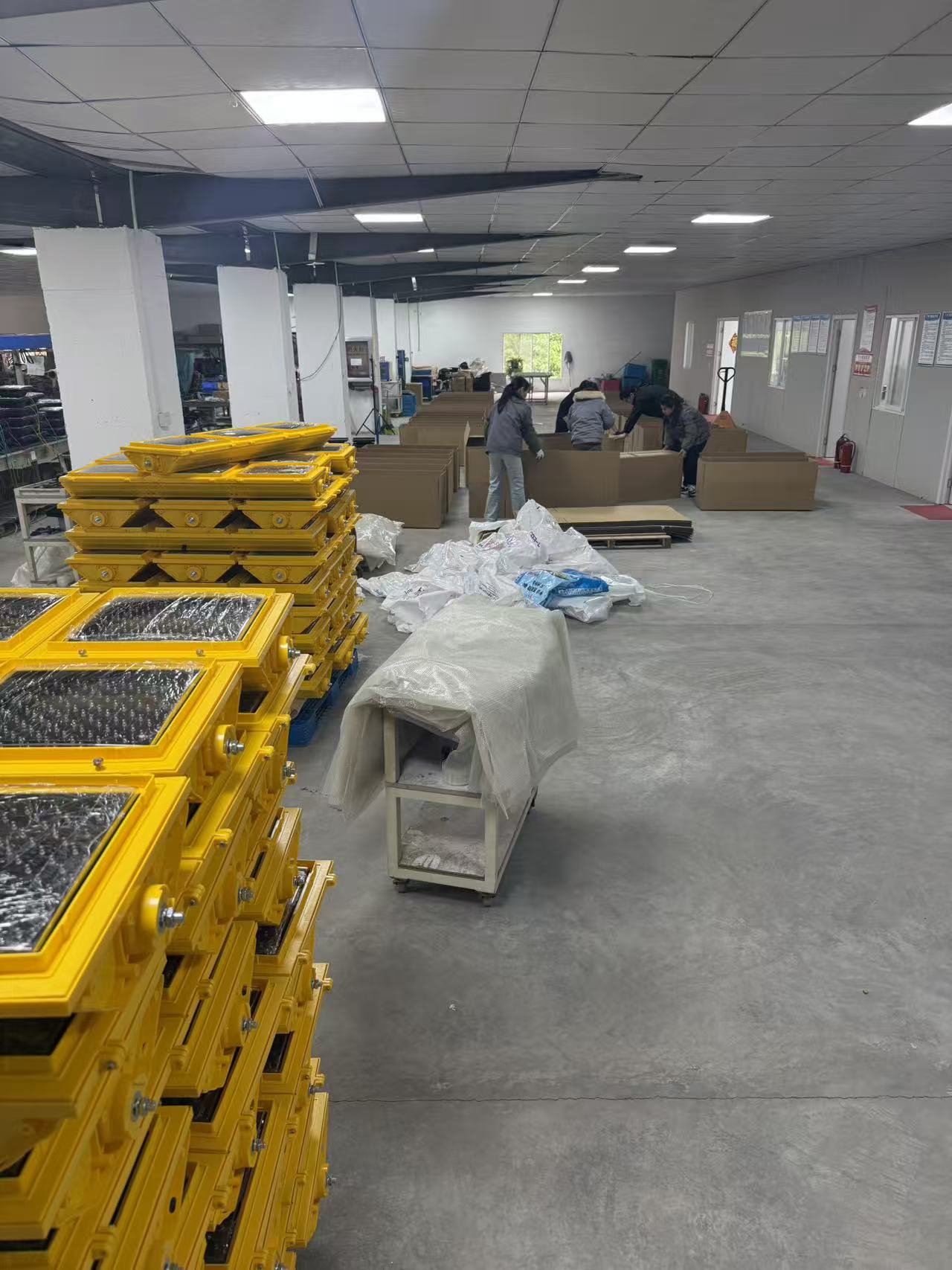 Yellow traffic signal housings staged near packing stations